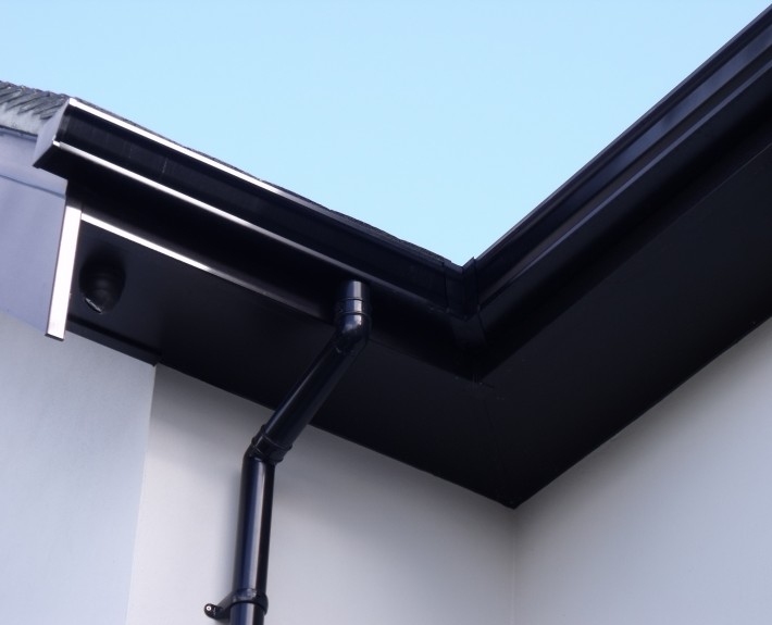 Close-up of Fascias, Soffits, Seamless Aluminium Gutter and PVC Drain Pipe